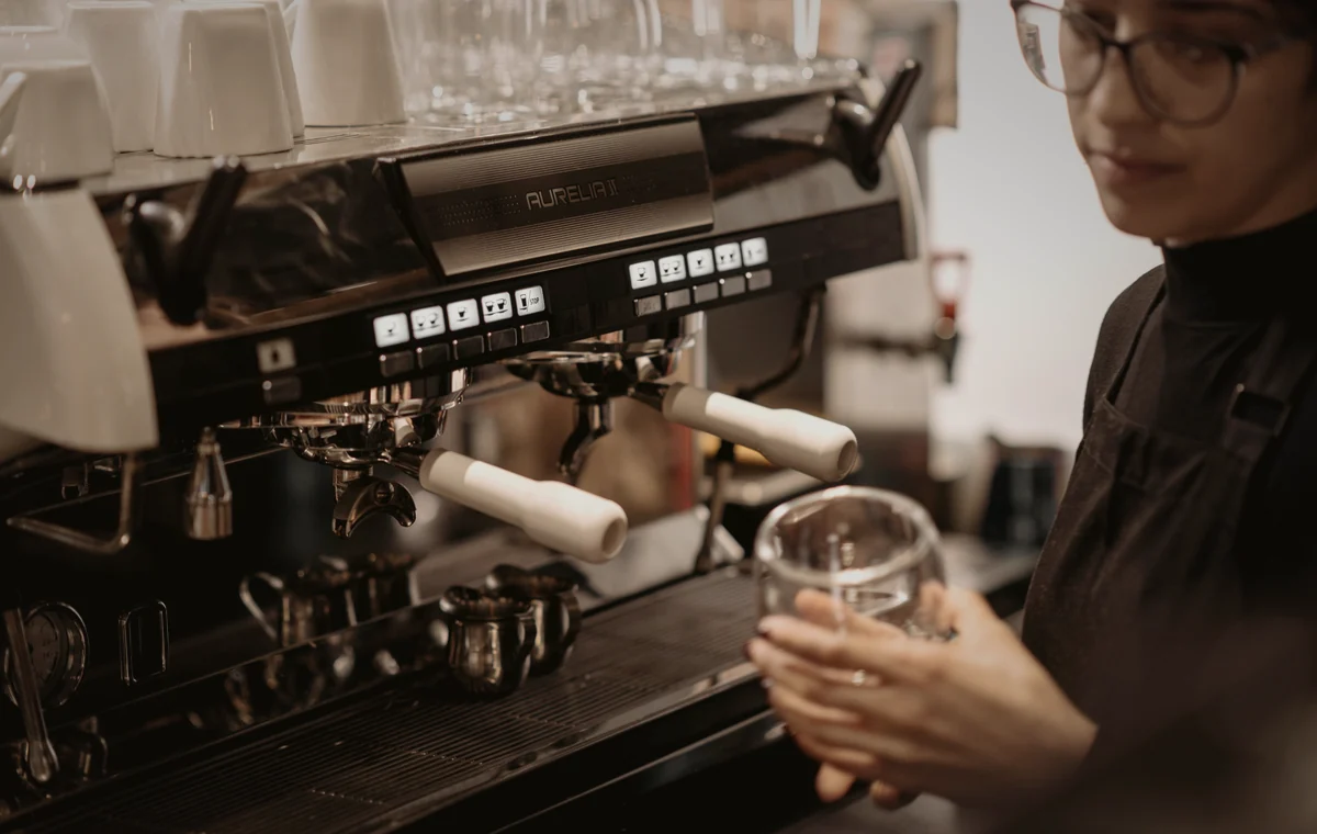 HBS Barista bereitet Kaffee an einer Siebträgermaschine zu